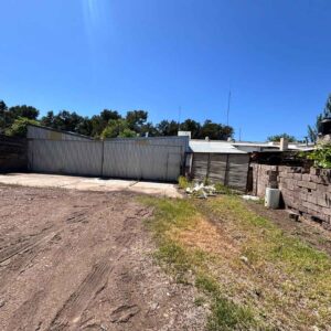 Vista del galpón y muro perimetral del terreno en propiedad comercial de Bowen