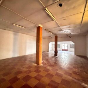 Amplio salón comercial con cielorraso suspendido y columnas