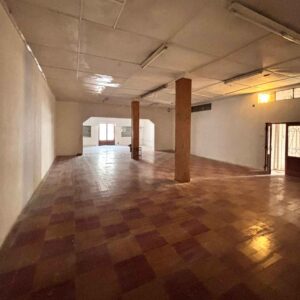 Amplio espacio cubierto con columnas de madera, ideal para depósito o showroom comercial