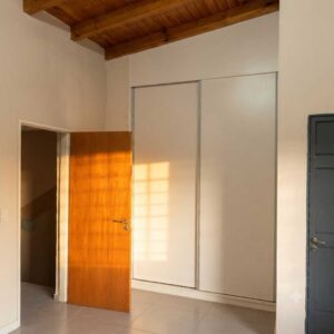 Dormitorio con placard empotrado y puerta de madera, dúplex en alquiler General Alvear
