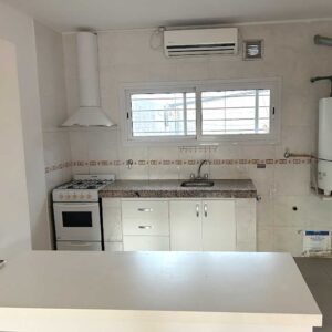 Detalle de mesada, anafe y muebles bajo mesada en la cocina del dúplex en alquiler