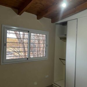 Dormitorio con placard y ventana al arbolado, planta alta del dúplex en alquiler