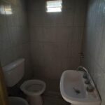 Baño con lavatorio, inodoro, bidet, ducha y ventana de ventilación.