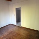 Ambiente superior con piso de madera, vigas a la vista y acceso interior.